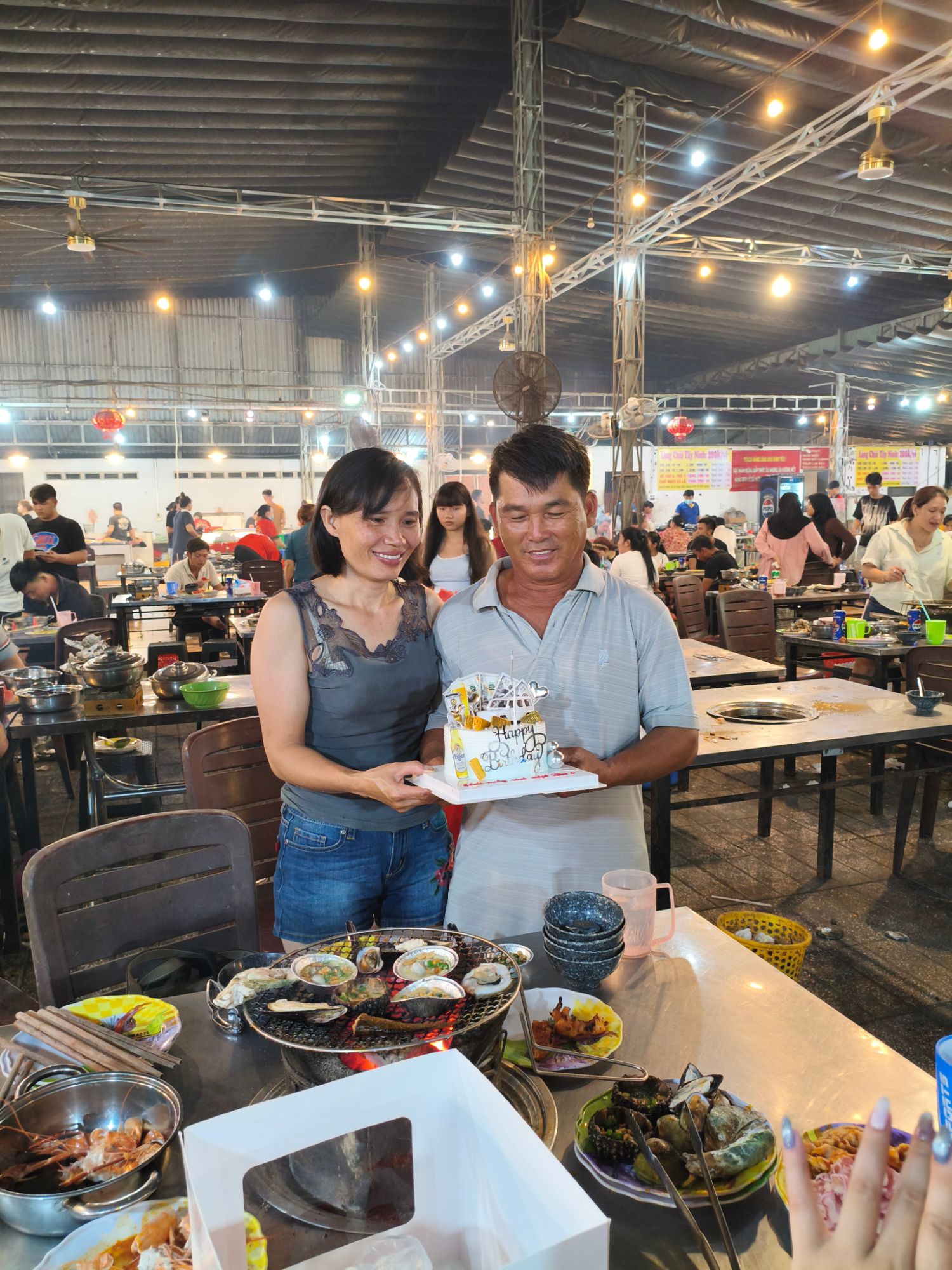 Mẹ và ba cùng cầm bánh sinh nhật